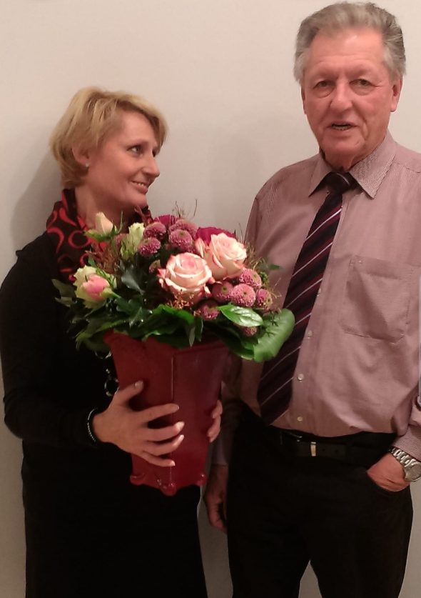 Evelyn Sieker hält einen Blumenstrauß, neben ihr steht ihr Vater, der Gründer des Salons